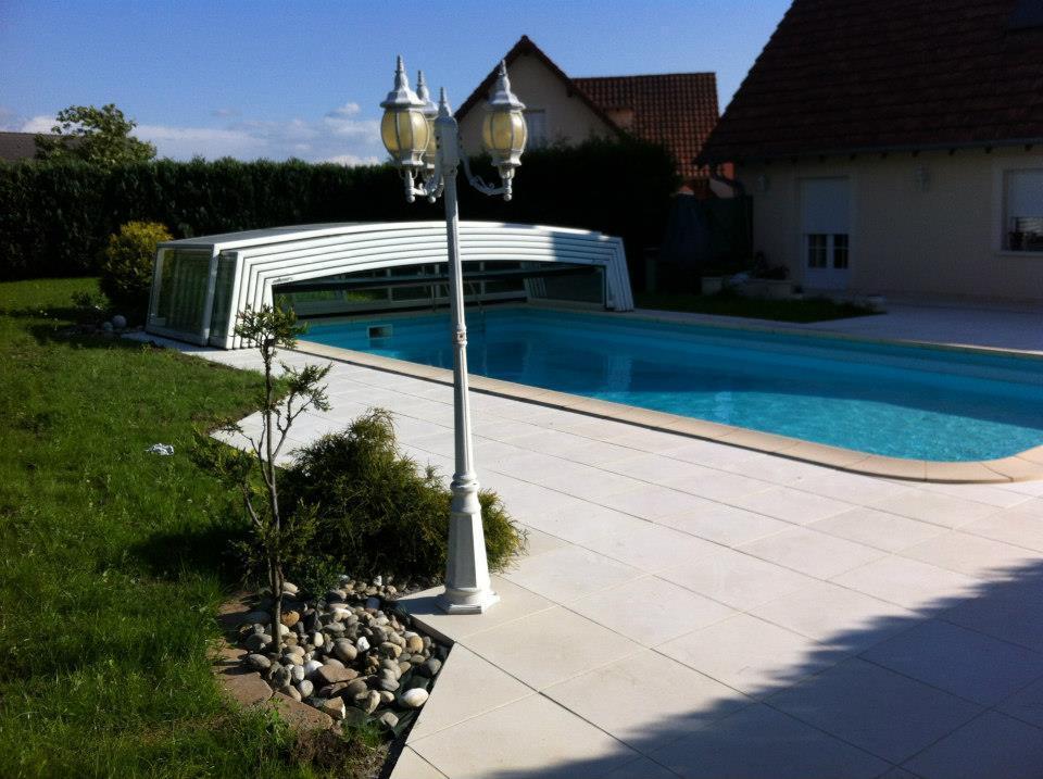 gazon entretenu autour d'une piscine creusée dans un jardin